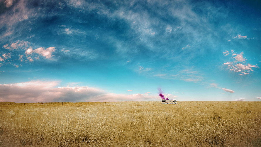 Breaking Bad RV in Golden Prairie Under Vast Blue Sky with Purple Smoke Trail HD wallpaper