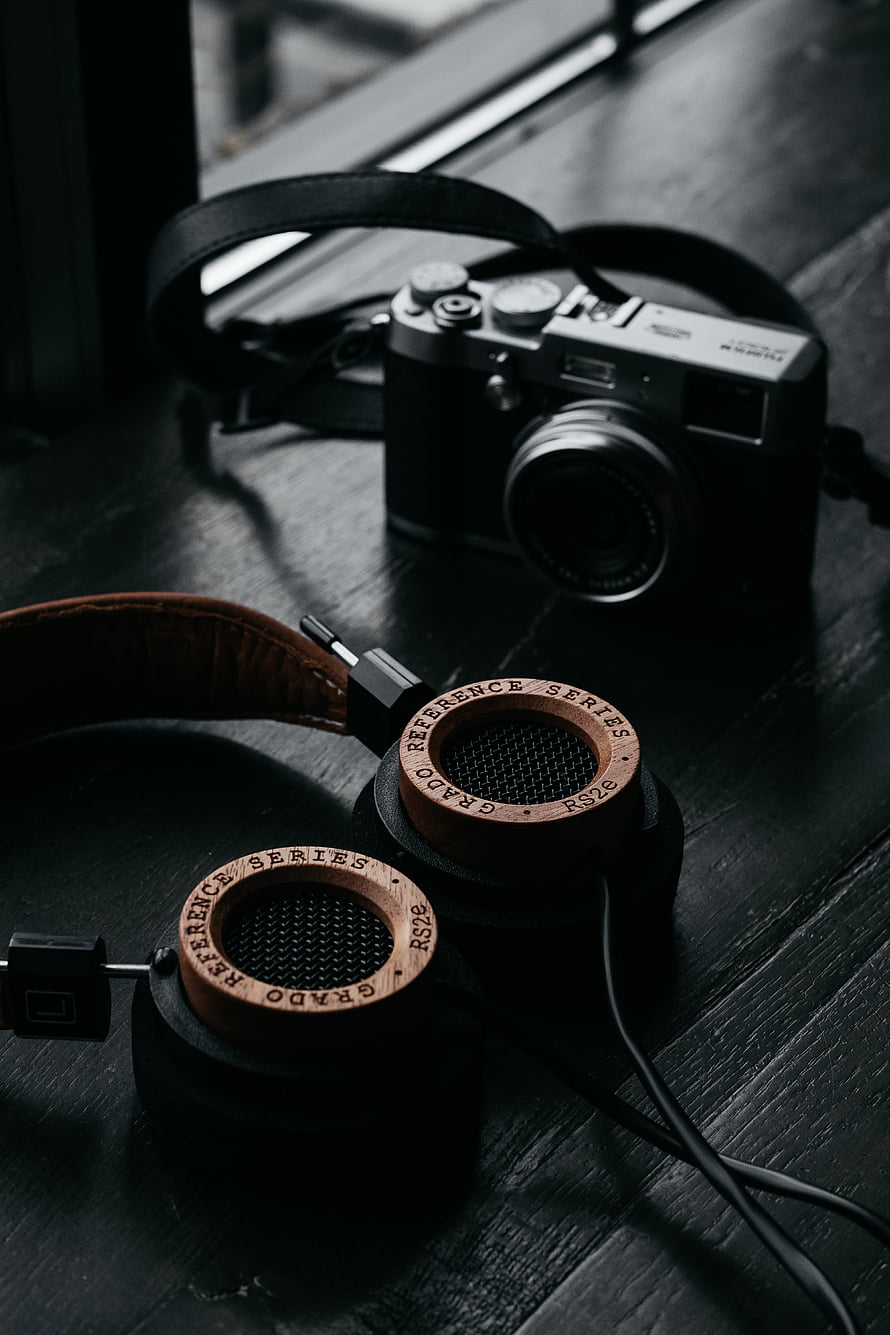 Grado RS2e Reference Series Headphones and Vintage Camera on Dark Wood Surface HD phone wallpaper