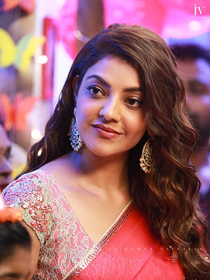 Kajal Agarwal in a vibrant pink embroidered saree with traditional jhumka earrings at a festive event HD phone wallpaper