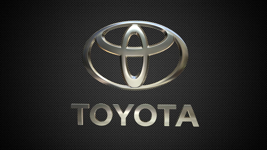 Sleek Metallic Toyota Emblem on Dark Carbon Fiber Texture HD wallpaper