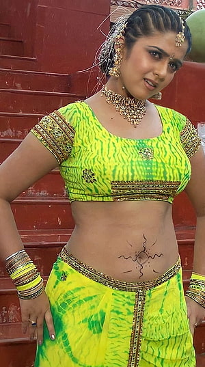 Woman in vibrant green tie-dye traditional outfit with gold jewelry and belly art, Charmi Kaur, telugu actress, navel HD phone wallpaper