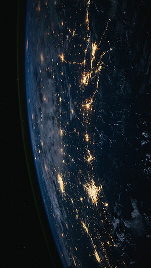 Earth at Night From Space Showing City Lights and Clouds HD phone wallpaper