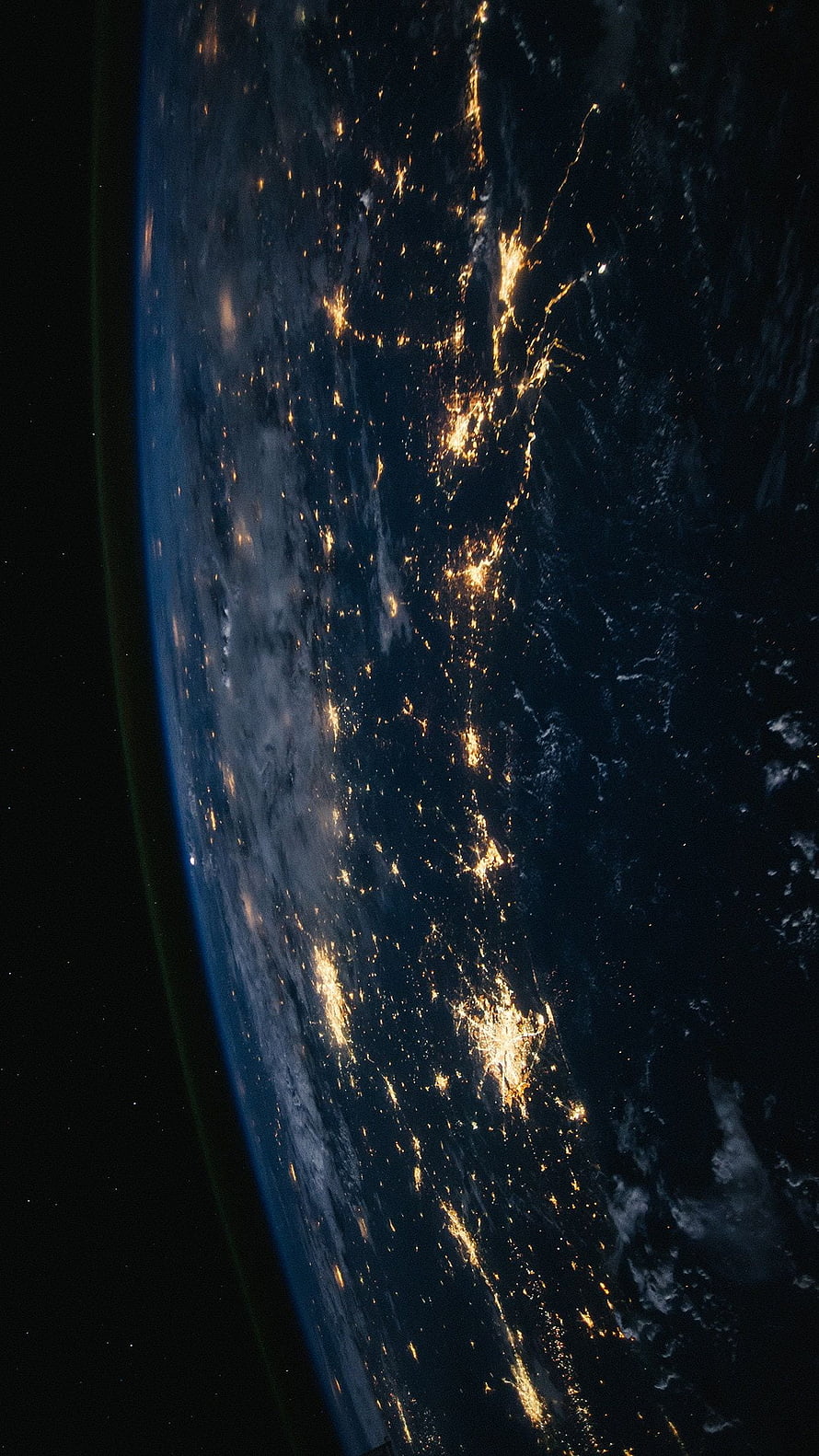 Earth at Night From Space Showing City Lights and Clouds HD phone wallpaper