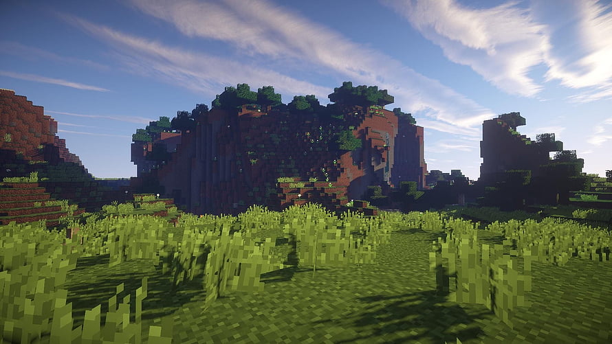 Minecraft Landscape With Lush Green Grass And Blocky Mountains Under Blue Sky HD wallpaper