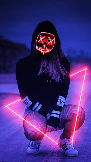 Person in black hoodie wearing a red LED mask with neon triangle light prop HD phone wallpaper