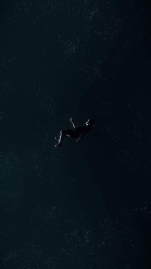 Silhouette of a person floating in deep space surrounded by stars HD phone wallpaper