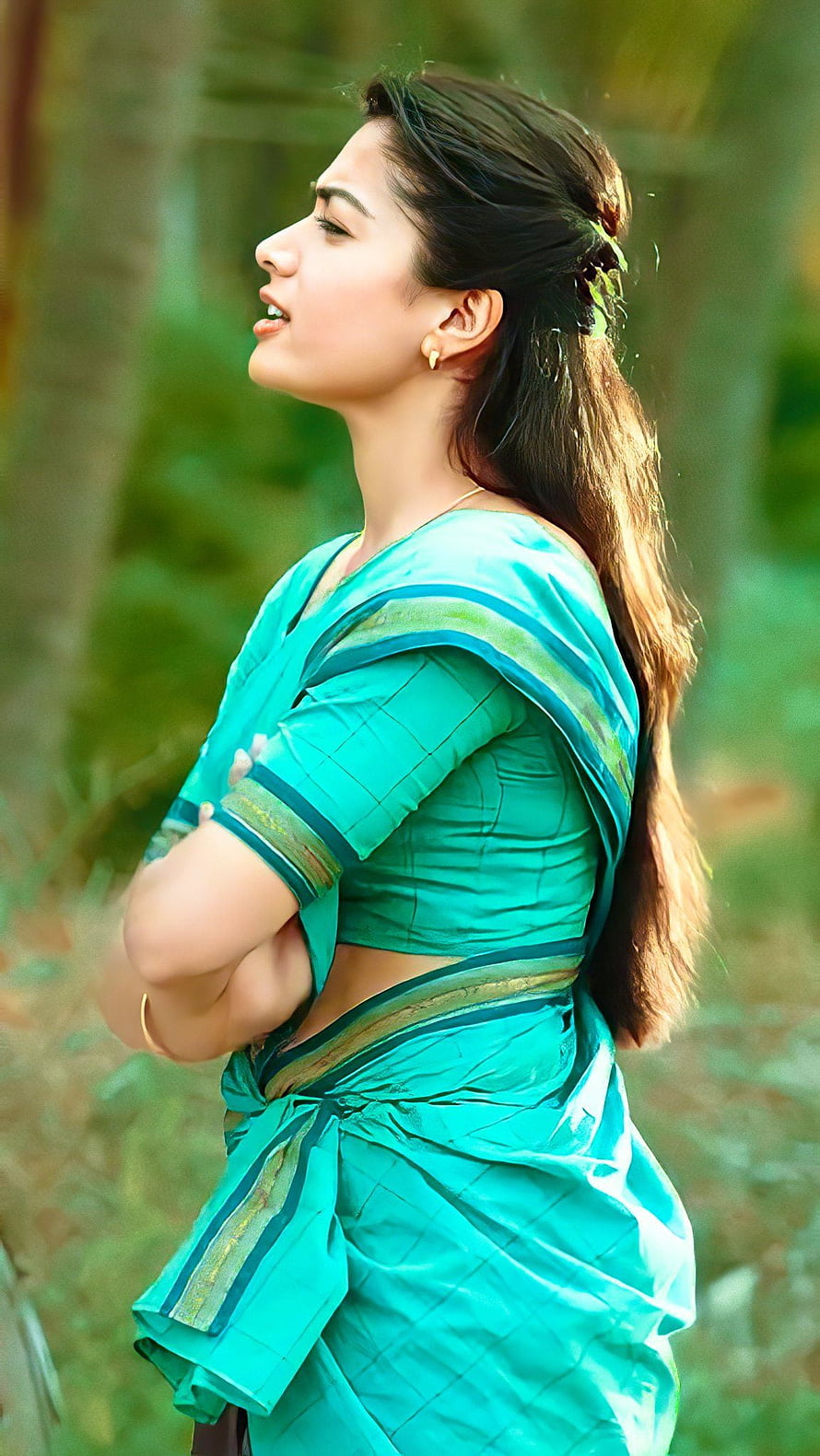 Rashmika Mandanna in a Turquoise Saree with Arms Crossed in a Lush Green Forest HD phone wallpaper