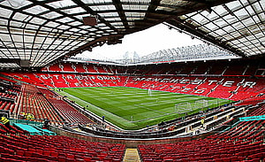 Old Trafford Stadium Interior View with Manchester United Red Seating and Pitch HD wallpaper