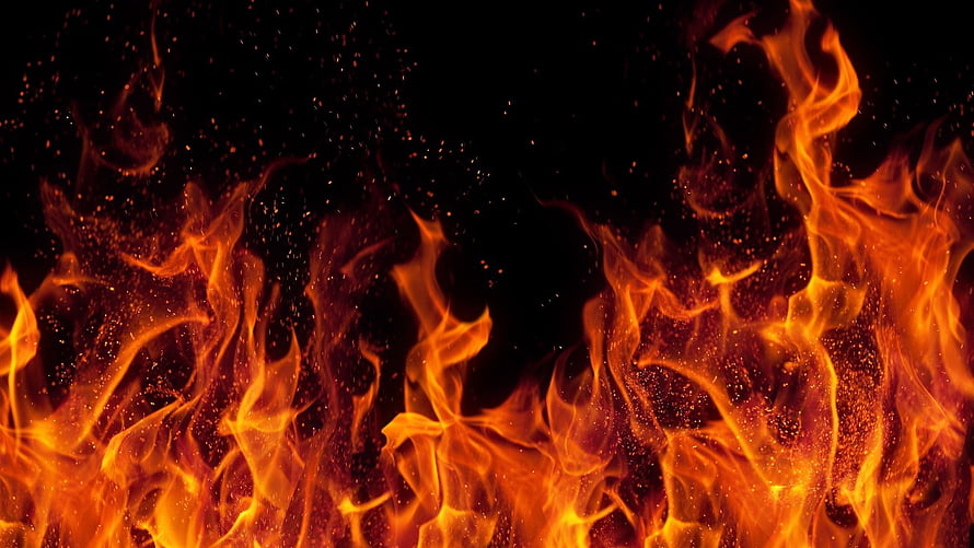 Vibrant Orange Flames and Glowing Embers Against a Deep Black Background HD wallpaper