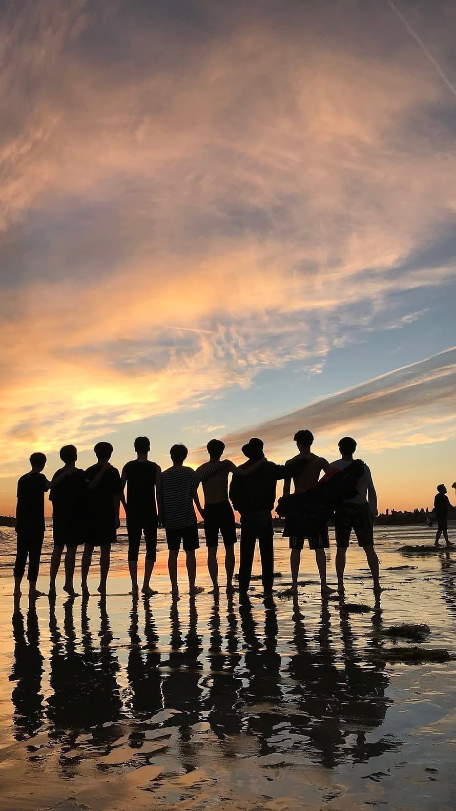 Silhouette of a group of friends standing on a beach at sunset with reflections in the water HD phone wallpaper