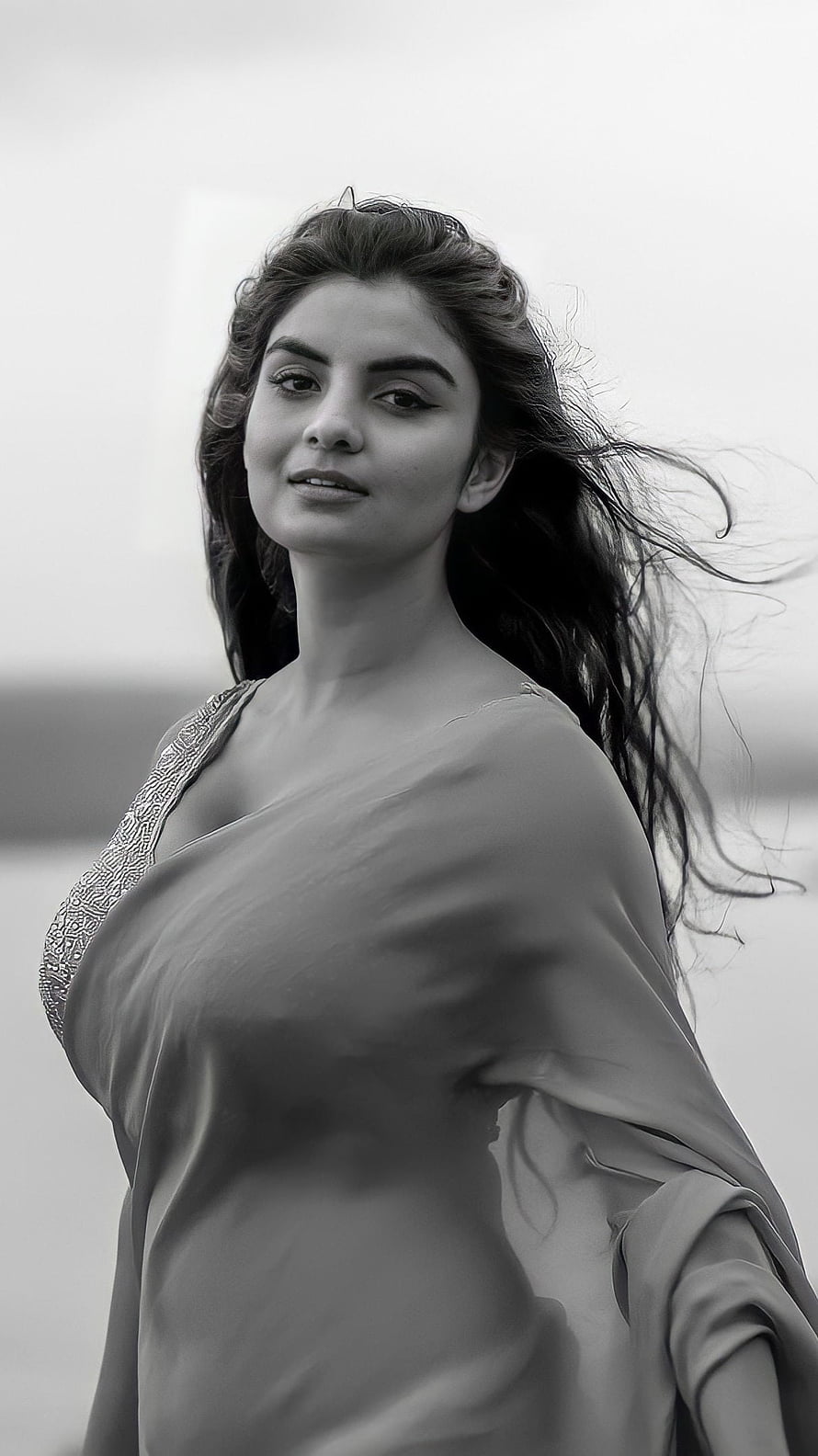 Anveshi Jain in a flowing saree with wind-blown hair in a monochrome portrait HD phone wallpaper
