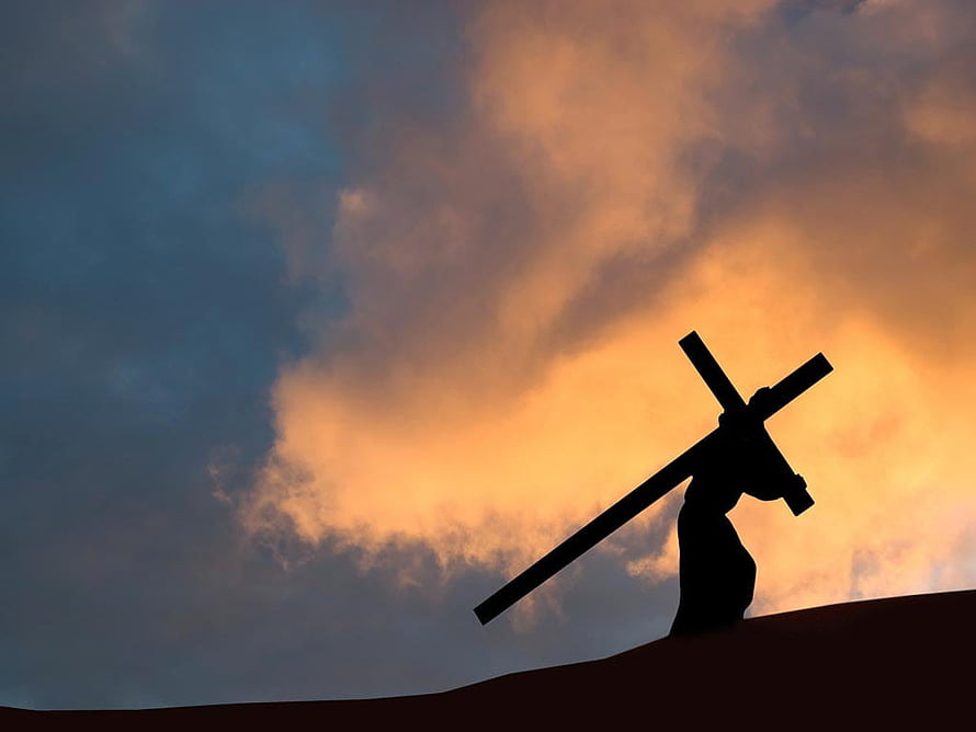 Silhouette of Jesus Carrying the Cross Against a Dramatic Sunset Sky HD wallpaper