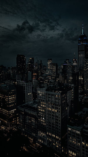 New York City Skyline at Night with Empire State Building Under Stormy Clouds HD phone wallpaper