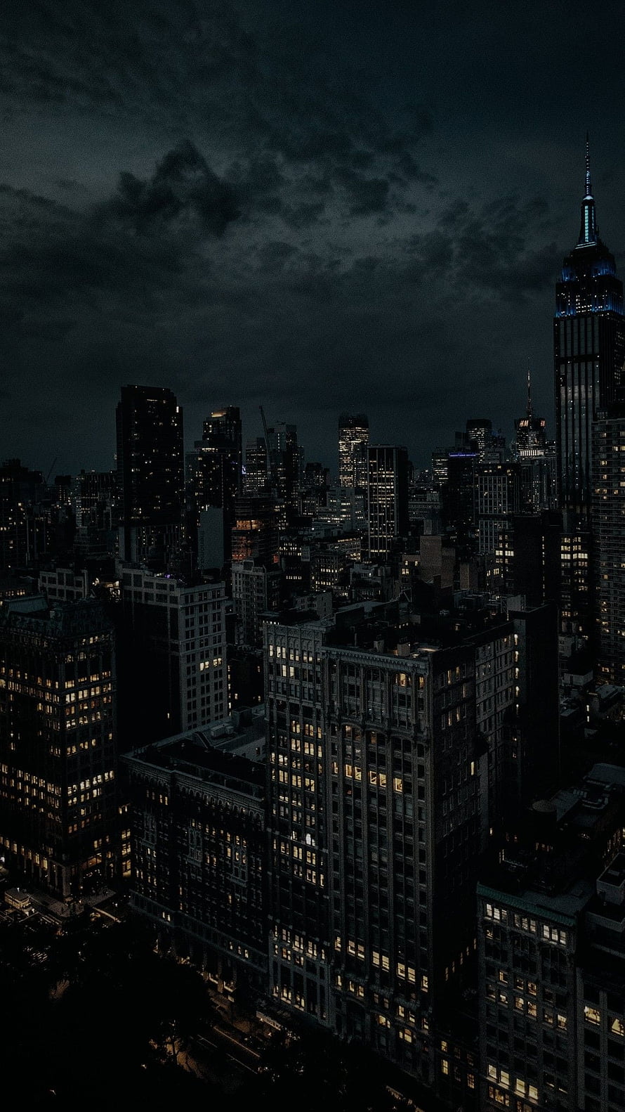 New York City Skyline at Night with Empire State Building Under Stormy Clouds HD phone wallpaper