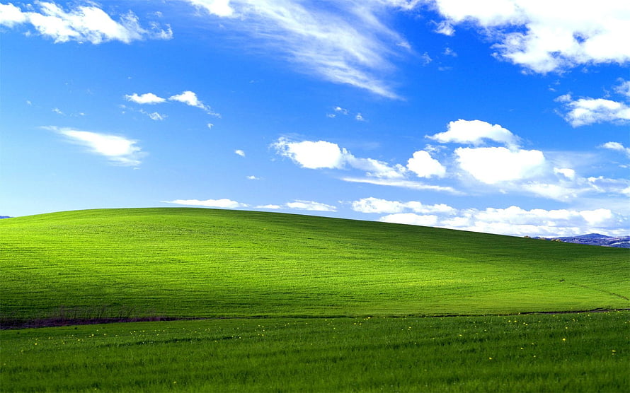 Rolling Green Hills Under a Bright Blue Sky with Scattered White Clouds HD wallpaper