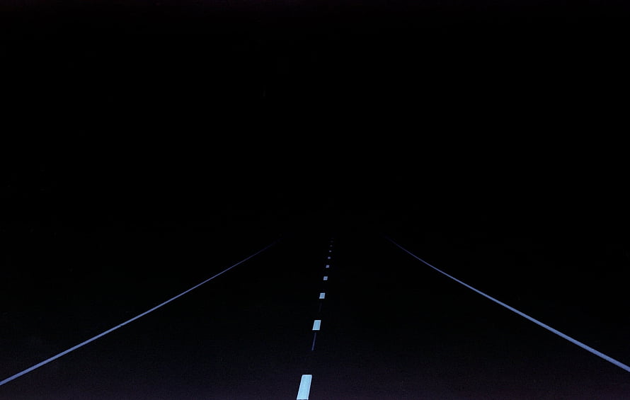 Dark Road at Night with White Lane Markers Disappearing into the Void HD wallpaper