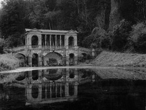 Classical Stone Pavilion with Arched Bridge Reflected in a Calm Lake HD wallpaper