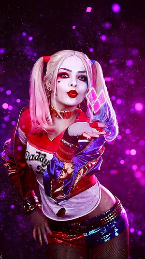 Harley Quinn in iconic red and blue costume with pink and blue pigtails against a vibrant purple bokeh background HD phone wallpaper