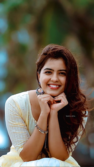 Amritha Aiyer smiling portrait in a cream kurta with long wavy hair and silver jewelry HD phone wallpaper