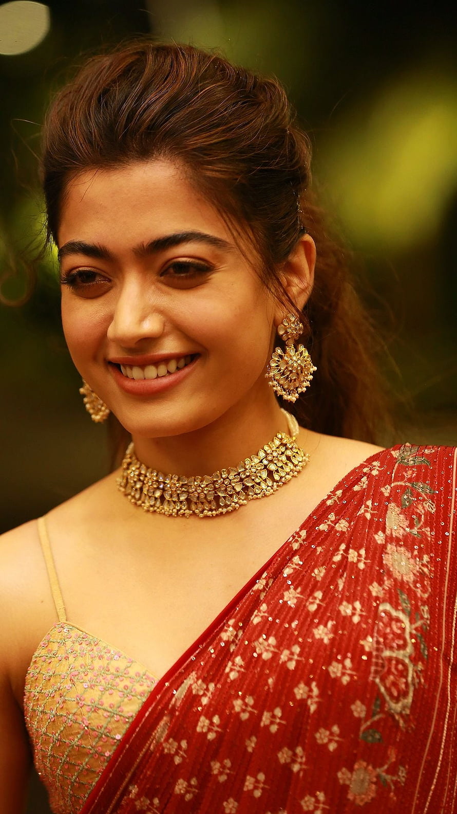 Rashmika Mandanna in a red embroidered saree with gold jewelry and an elegant updo hairstyle HD phone wallpaper