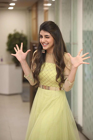 Pooja Hegde in a stunning light green net gown with gold embroidery and a decorative belt, smiling and waving with hands raised HD phone wallpaper