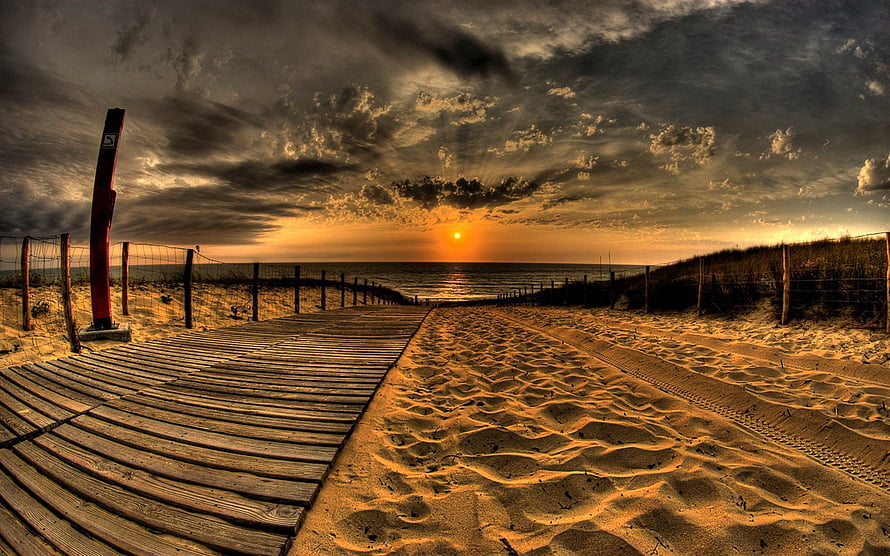 Dramatic Golden Hour Beach Scene With Wooden Boardwalk Leading To Ocean Horizon HD wallpaper
