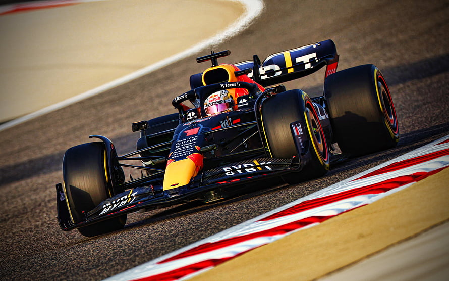 Red Bull Racing Formula 1 car speeding around a track corner with red and white curbs HD wallpaper