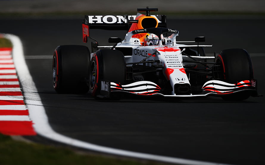 Oracle Red Bull Racing Formula 1 car cornering on a race track with red and white curbing HD wallpaper