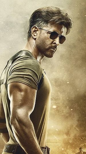 Hrithik Roshan in Tiger 3 wearing sunglasses and tactical gear in a dusty action scene HD phone wallpaper