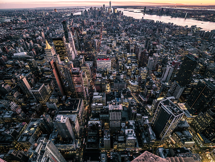 Aerial View of New York City Skyline at Sunset with Illuminated Skyscrapers and River HD wallpaper