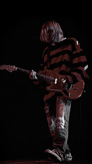 Kurt Cobain performing on stage in striped sweater and distressed jeans HD phone wallpaper