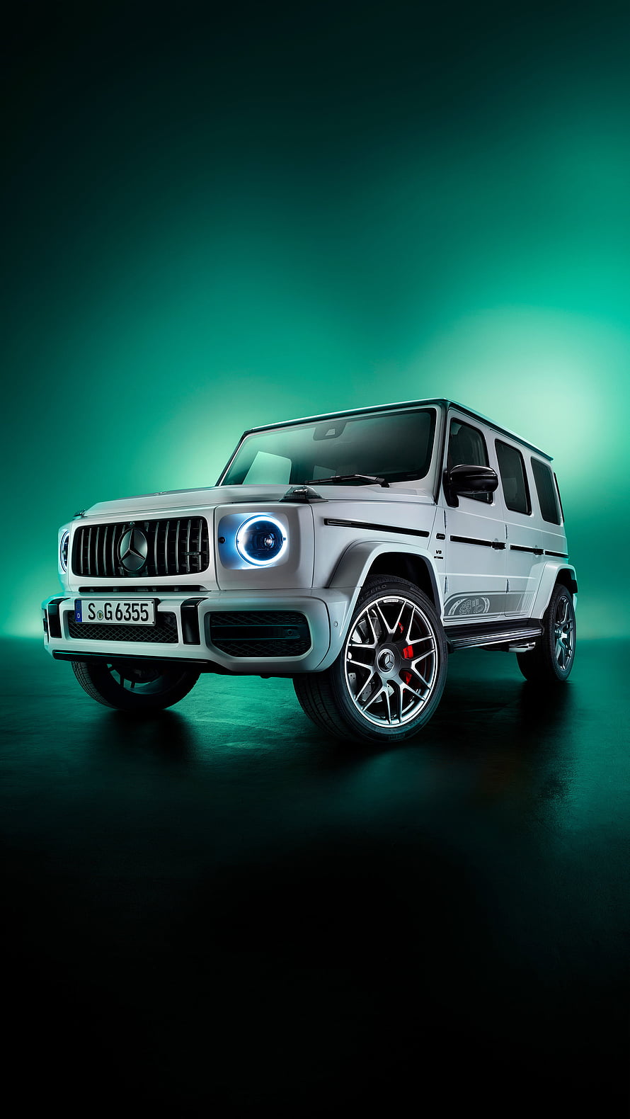 White Mercedes-AMG G63 SUV with glowing headlights against a teal background HD phone wallpaper