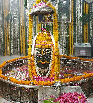 Sacred Kala Bhairava Idol Adorned With Marigold Garlands And Silver Umbrella In Temple HD phone wallpaper