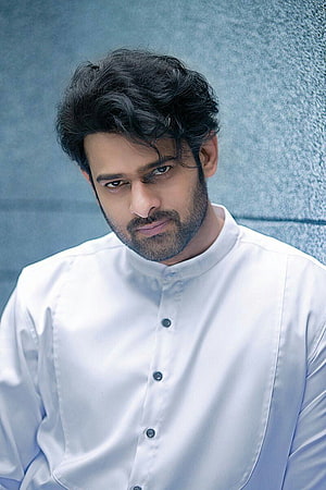 Prabhas Portrait in White Band Collar Shirt Against Textured Blue Wall HD phone wallpaper