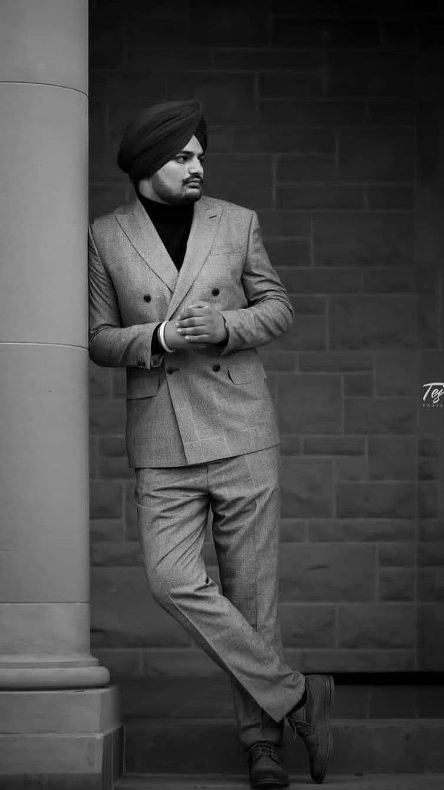 Sidhu Moose Wala in a double-breasted suit and turban leaning against a stone column in black and white HD phone wallpaper