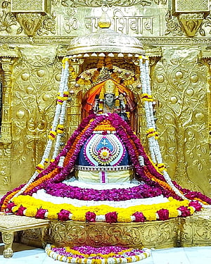 Somnath Mahadev Jyotirlinga adorned with vibrant floral garlands and golden temple architecture HD phone wallpaper