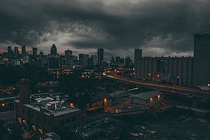 Montreal skyline at dusk under dramatic storm clouds with illuminated city lights HD wallpaper