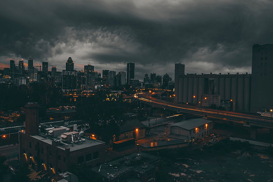 Montreal skyline at dusk under dramatic storm clouds with illuminated city lights HD wallpaper