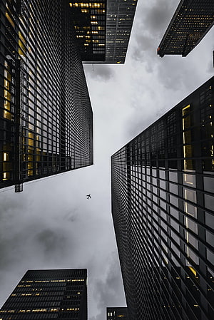 Looking Up at Dark Glass Skyscrapers Against a Cloudy Sky HD phone wallpaper