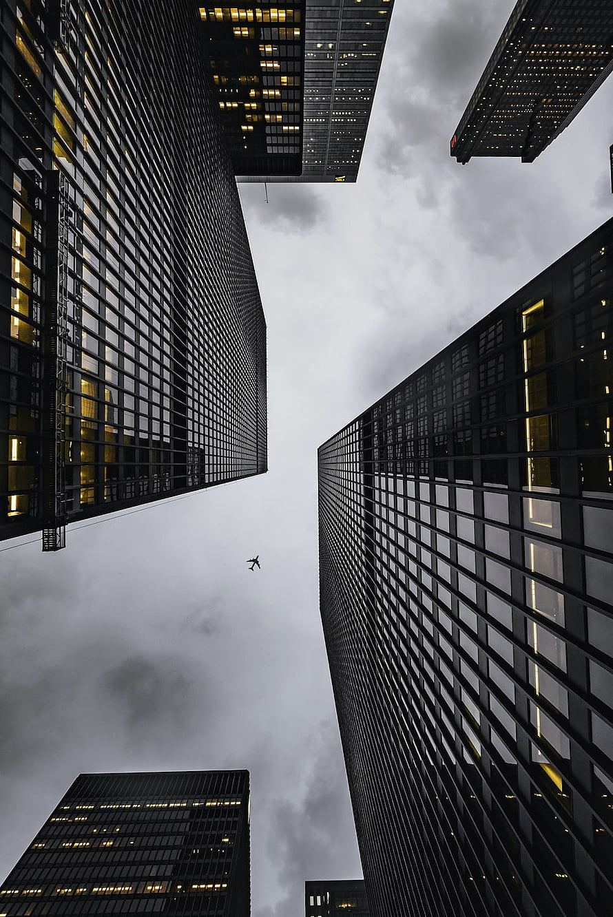 Looking Up at Dark Glass Skyscrapers Against a Cloudy Sky HD phone wallpaper