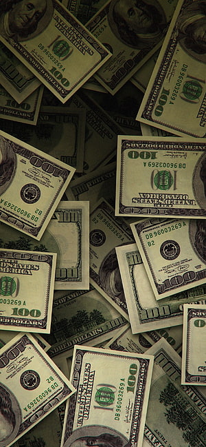 Scattered pile of one hundred dollar bills with Benjamin Franklin portrait and green treasury seals HD phone wallpaper