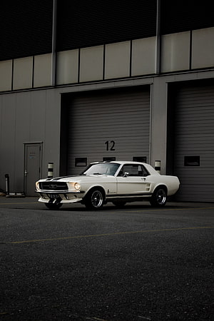 Classic White Ford Mustang Fastback Parked in Industrial Garage Bay HD phone wallpaper