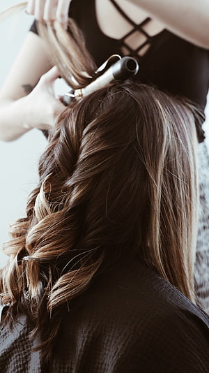 Stylist Creating Loose Waves With Curling Iron On Long Brown Hair HD phone wallpaper