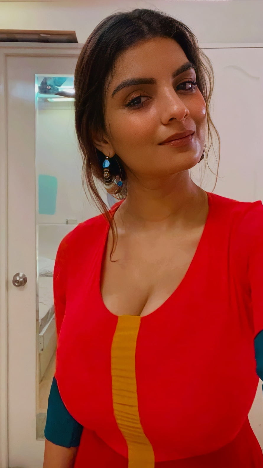 Jyotika in a vibrant red dress with yellow and blue accents, posing indoors with a warm smile HD phone wallpaper