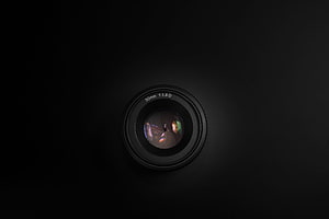 Minimalist 50mm Prime Camera Lens with Aperture Blades on Black Background HD wallpaper