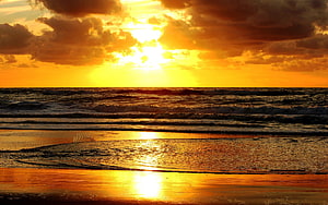 Golden Ocean Sunset with Dramatic Clouds and Shimmering Beach Reflections HD wallpaper