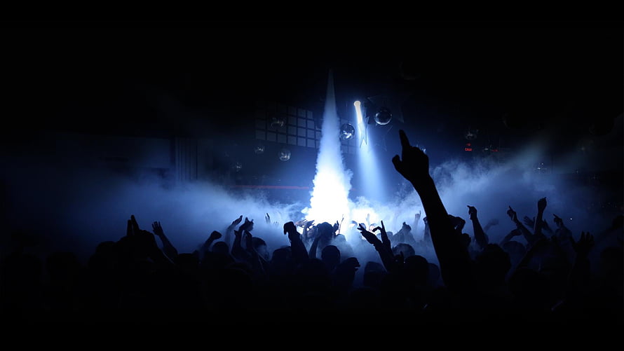Silhouetted Crowd at a Rave with Blue Stage Lights and Fog HD wallpaper