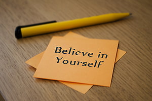 Motivational Sticky Note with Believe in Yourself Text and Yellow Pen on Wooden Desk HD wallpaper