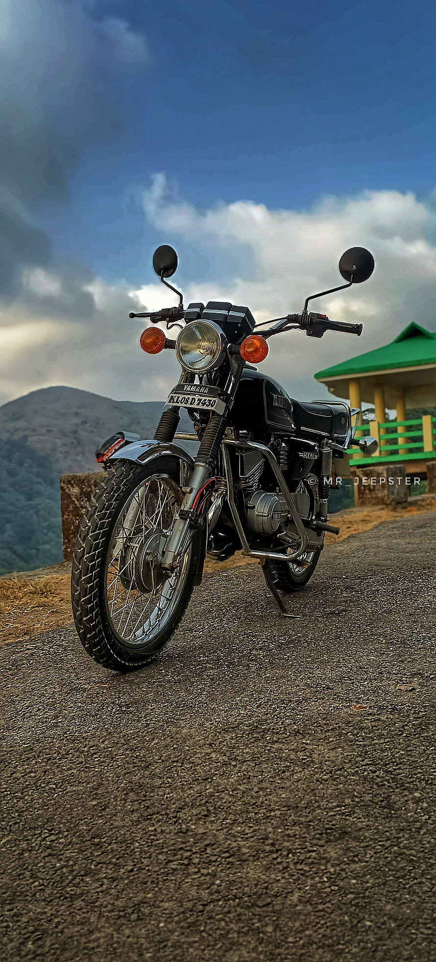 Classic Yamaha RX100 Motorcycle Parked on a Mountain Road with Scenic Hills and Blue Sky HD phone wallpaper