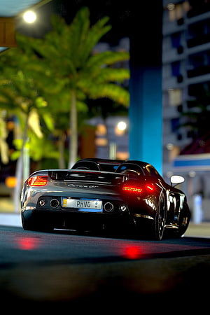 Porsche Carrera GT rear view at night with glowing taillights and palm trees HD phone wallpaper